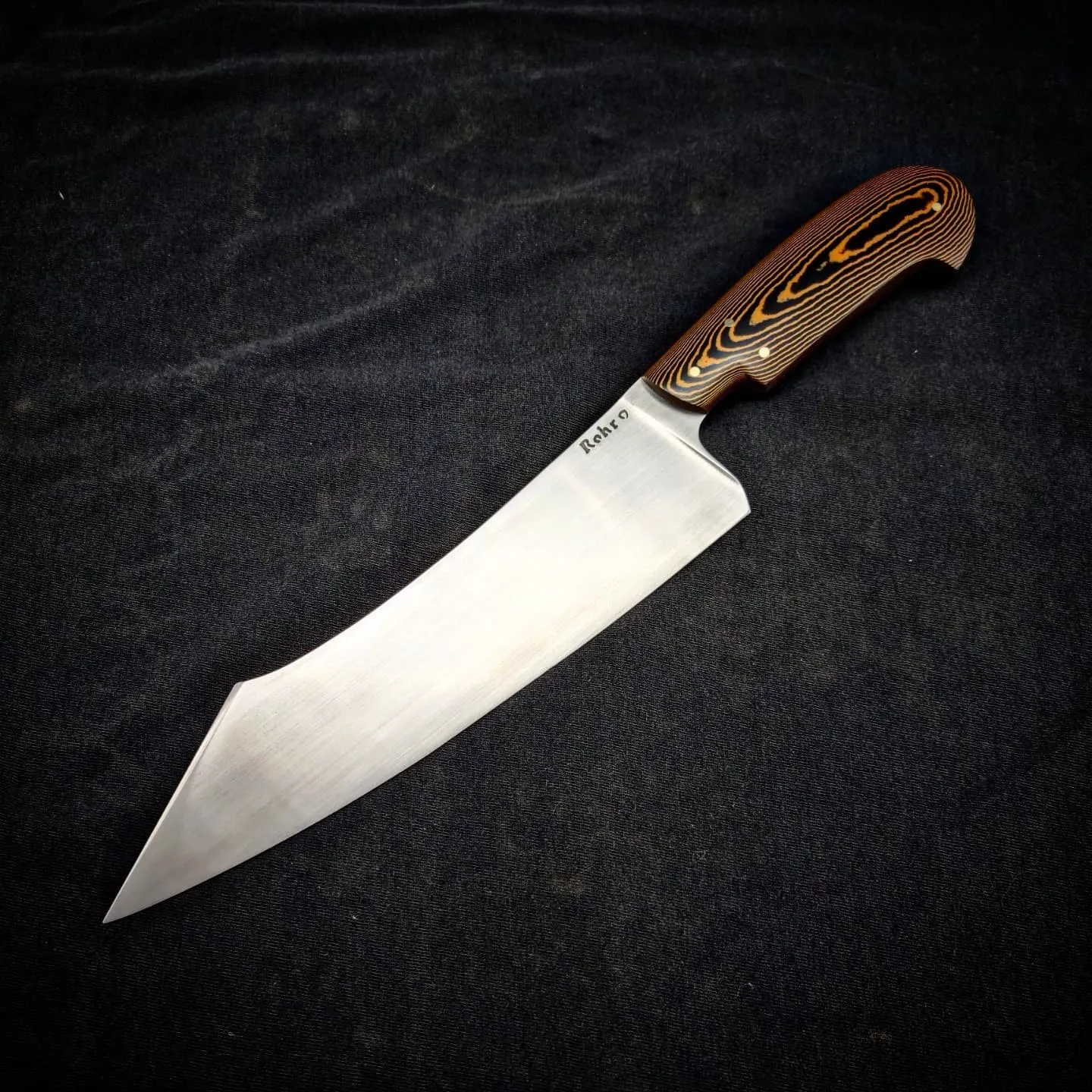 Cuchillo de cocina con hoja de acero pulido y cabo de micarta marrón, sobre fondo negro